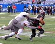 Cedar Grove's Ricky Lee (1) and Quinterio Lawson (2) team up for a tackle during the Saints state championship win over Carver last December. (Photo by Mark Brock)