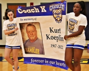 Chamblee Lady Bulldog basketball team members Alissa McKinzy (left) and Alana Azeta (right) present the banner going up in the Chamblee gym to honor the late Kurt Koeplin, the former girls' basketball coach and gold team coach at Chamblee who passed away suddenly in June. (Photo by Mark Brock)