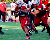 Martin Luther King Jr.'s Jamarcus Hunter (21) picks up some yardage on the Lions' opening scoring drive with the help of lineman Jeremiah Blaylock (58). (Photo by Mark Brock)