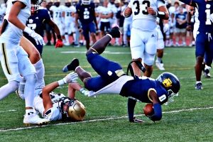 Southwest DeKalb's Joshua Jones (0) dives over a St. Pius defender into the end zone for an early touchdown of the Panthers' tough 28-27 loss to the Golden Lions on Thursday. (Photo by Mark Brock)