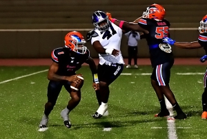 Columbia quarterbac Cameron Graves (1) scrambles away from the pressure put on by Miller Grove's Mrlon McClean (41) as teammate Antonio Wihiters (55) tries to block the Wolverine. (Photo by Mark Brock)