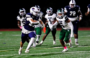 Dunwoody's Cameron Irastorza (left) runs for a big gain as Arabia Mountain's Jaden Sancho (5) gives chase. Irastorza had a rushing and receiving touchdown in Dunwoody's 28-19 win. (Photo by Mark Brock)