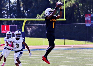 Lithonia's Timothy Behling leaps high for a catch during the Bulldogs tough 20-14 loss to Chapel Hill in the first round of the Trail to the Title playoffs. Behling had a 51-yard touchdown run and a 15-yard pick-six in the losing cause. (Photo by Mark Brock)