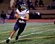 Redan quarterback Dameon Jones rolls to his right looking for a receiver during fourth quarter action in a 41-6 loss to Miller Grove. (Photo by Mark Brock)