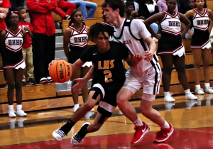 Lithonia's Rayshun Williams (2) drives inside past Druid Hills' Reese Hamburger (11) during the Bulldogs 75-47 Region 5-4A win. (Photo by Mark Brock)